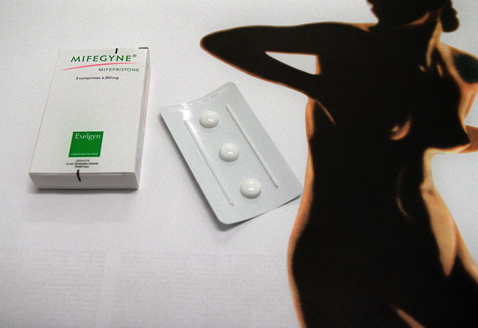 An image of the abortion pill next to the outline of a woman&#39;s body