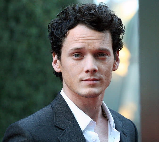 Anton Yelchin in a suit looking at the camera