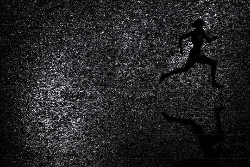 Lea Sprunger of Team Switzerland runs through heavy rain during the women's 400m semifinal.