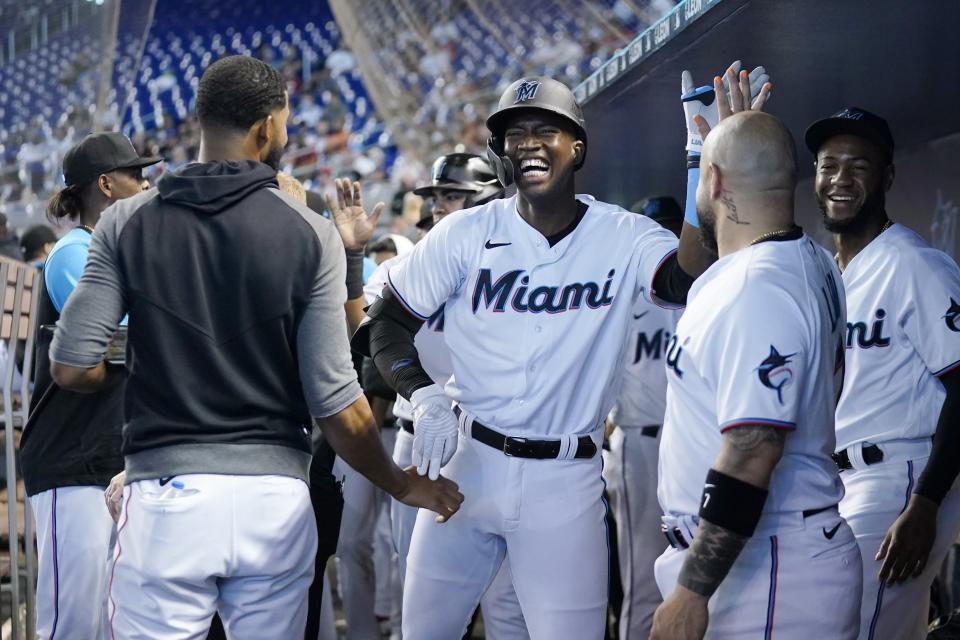 Miami Marlins' Jesus Sanchez, center, celebrates in the dugout after hitting a two-run home run during the first inning of a baseball game against the Cincinnati Reds, Sunday, Aug. 29, 2021, in Miami. (AP Photo/Lynne Sladky)