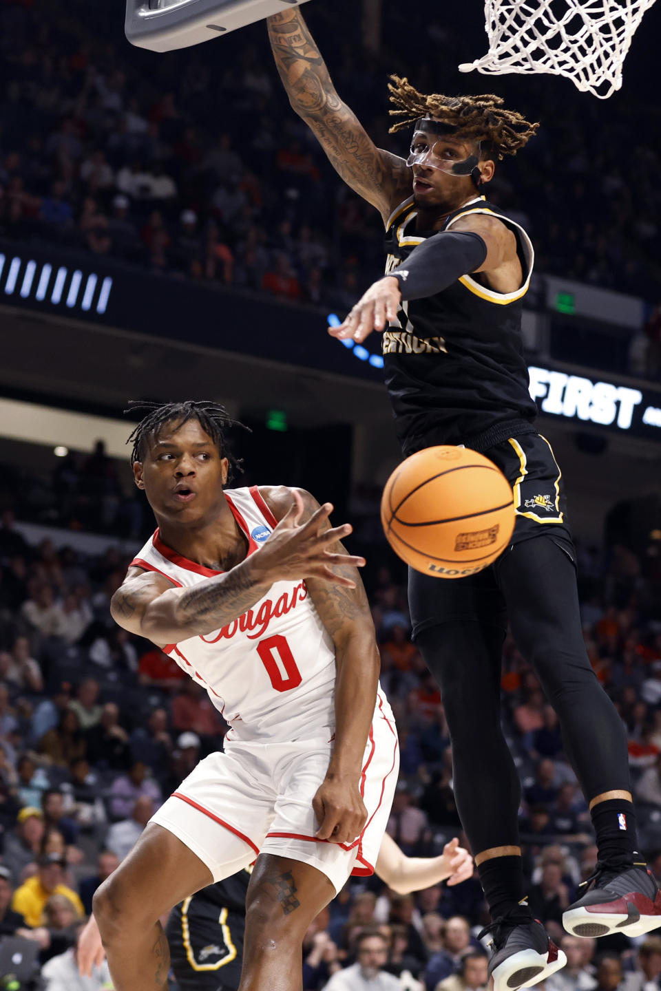 Houston guard Marcus Sasser (0) passes the ball as Northern Kentucky forward Chris Brandon (21) defends during the first half of a first-round college basketball game in the men's NCAA Tournament in Birmingham, Ala., Thursday, March 16, 2023. (AP Photo/Butch Dill)