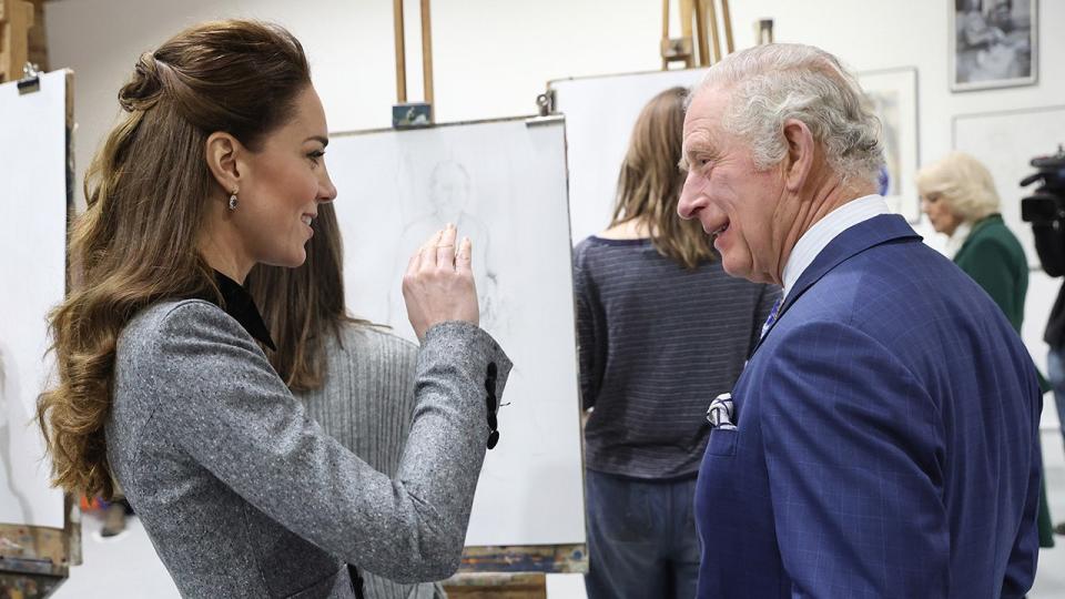Kate Middleton wearing a grey dress chatting with King Charles