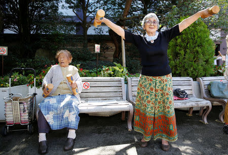 Natsu Naruse (L), 100 year-old, and other partcipants exercise with wooden dumbbells during a health promotion event to mark Japan's "Respect for the Aged Day" at a temple in Tokyo's Sugamo district, an area popular among the Japanese elderly, Japan, September 18, 2017. REUTERS/Toru Hanai