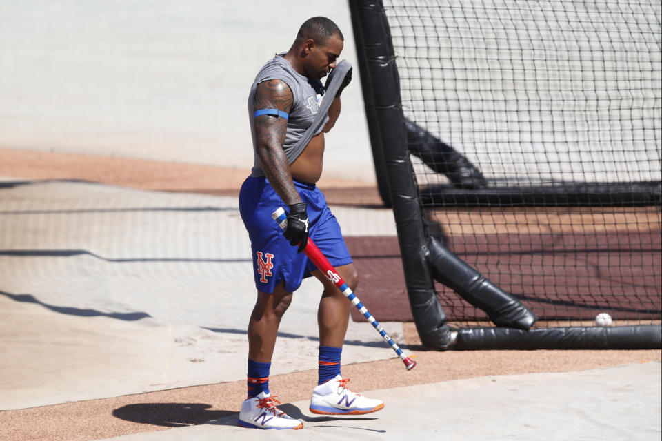 New York Mets Yoenis Cespedes wipes his face with his tee-shirt after taking some repetitions in the batting cage during a summer training camp workout at Citi Field, Thursday, July 16, 2020, in New York. (AP Photo/Kathy Willens)