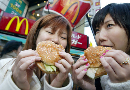 Japanese teenagers enjoy McDonald's Big Macs in Tokyo December 24, 2003. REUTERS/Eriko Sugita/File Photo