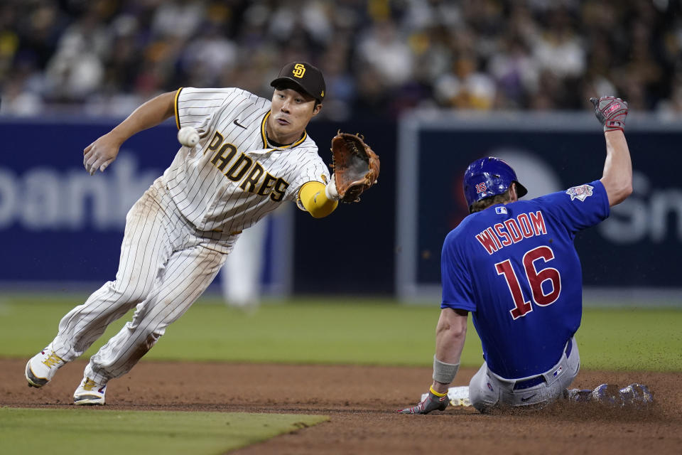 San Diego Padres shortstop Ha-Seong Kim waits for throw as Chicago Cubs' Patrick Wisdom (16) arrives safely to second base, advancing from first off a wild pitch during the fifth inning of a baseball game Tuesday, May 10, 2022, in San Diego. (AP Photo/Gregory Bull)
