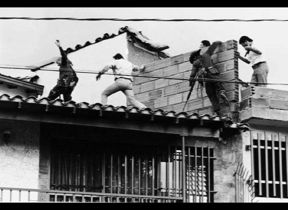 Colombian police and military forces storm the rooftop where drug lord Pablo Escobar was shot dead just moments earlier during an exchange of gunfire between security forces and Escobar and his bodyguard 02 December 1993. The death of Escobar and the bodygaurd ends a 16-month hunt for Escobar, who controlled one of the world's most ruthless drug trafficking empires. (Photo credit should read JESUS ABAD-EL COLOMBIANO/AFP/Getty Images)