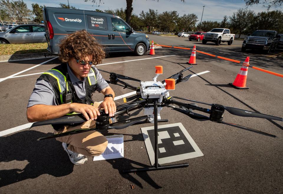 DroneUp shift lead Ryan Woodie flies a drone test flight in the parking lot of the Walmart Supercenter on Cypress Gardens Boulevard in Winter Haven Florida on January 24, 2023.