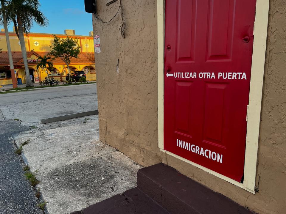 The door of an office offering services to immigrants sits across the street from a market in Immokalee, Florida, one of the spots where workers gather before dawn to board vans and buses to jobs in farm fields, construction sites and landscaping companies.