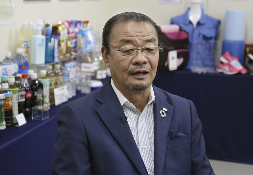 In this June 18, 2019, photo, Kyoei Industry Co., President Eiichi Furusawa speaks during an interview with The Associated Press at his office in Tokyo. At his plastic recycling company, about 35 tons of PET bottles are processed daily. They come in hundreds of bales, each wrapped in plastic, and are then unraveled, sorted, pulverized, heated and minced. Next they’re turned into fine pellets and reborn as egg cartons, school uniforms, soccer jerseys and other sports equipment, as well as PET bottles, returning to store shelves, said Furusawa. (AP Photo/Koji Sasahara)