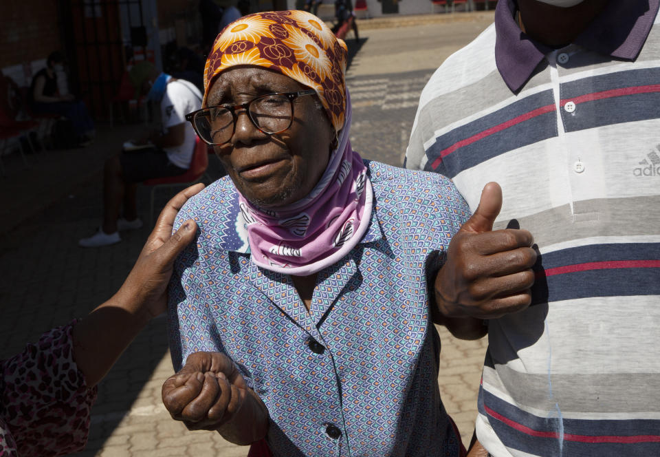 An elderly woman is assisted after casting her vote during local elections in Soweto, South Africa, Monday, Nov. 1, 2021. South Africa is holding crucial local elections Monday, the country has been hit by a series of crippling power blackouts that many critics say highlight poor governance. (AP Photo/Denis Farrell)