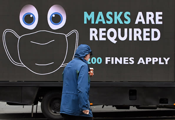 A man walks past a sign on a truck in Melbourne on as the city enforces strict lockdown restrictions after a fresh outbreak of the COVID-19 coronavirus.