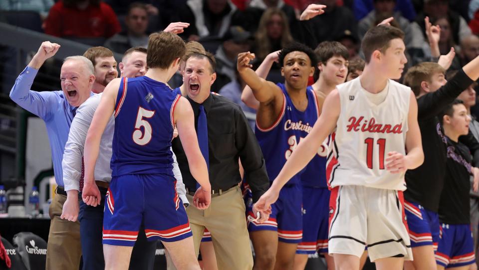 The Crestview bench celebrates after Mitch Temple's (left) three-point shot next to Hiland guard Sammy Detweiler during the second half of a Division IV state semifinal basketball game at UD Arena, Friday, March 17, 2023, in Dayton, Ohio.