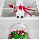 <p>El Elf sostenido en el aire por un bastón de Navidad tratando de asaltar los dulces de la cocina.<br>(Foto Instagram @elfontheshelf) </p>
