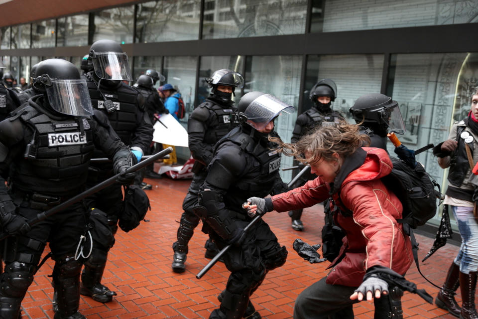 FILE - In the Feb. 20, 2017 file photo, protesters clash with police in Portland, Ore. The mayor of Portland, Oregon, is criticizing how local prosecutors and his own Police Bureau handle street violence among political factions that frequently clash on the city's streets. In a news conference Monday, March 11, 2019, Ted Wheeler called for a change to rules and laws if they do not allow police officers to arrest brawlers and vowed that anyone fighting on Portland streets will not escape unpunished. (Dave Killen /The Oregonian via AP, File)