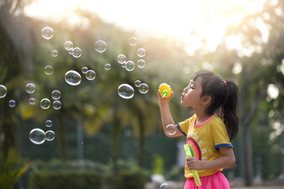 summer activities girl blowing bubbles