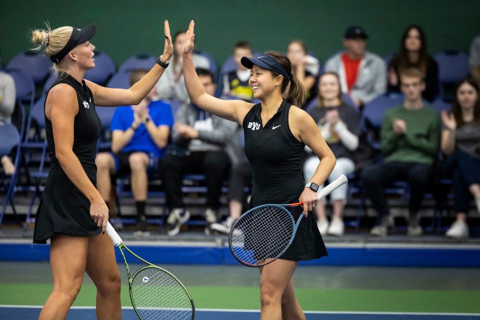 BYU doubles team fives each other during match against Washington in 2023. | Brooklynn Kelson, BYU Photo