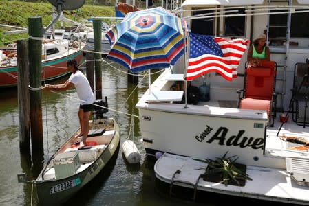 Marvin Foster, who lives in a ship with his wife Marilyn and plan to stay aboard during Hurricane Dorian, secures it at a marina in Merritt Island