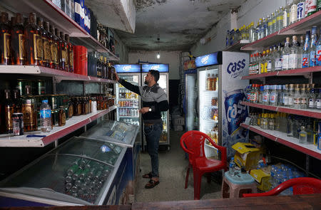 A man displays liquor in the shop, after it was banned during the Islamic State militants' seizure of the city, in Mosul, Iraq April 20, 2019. REUTERS/Abdullah Rashid