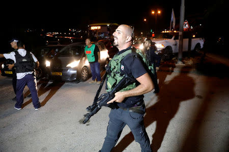 A security guard walks into the Israeli settlement Adam after a Palestinian assailant stabbed three people and then was shot and killed, according to the Israeli military, in the occupied West Bank, July 26, 2018. REUTERS/Ronen Zvulun