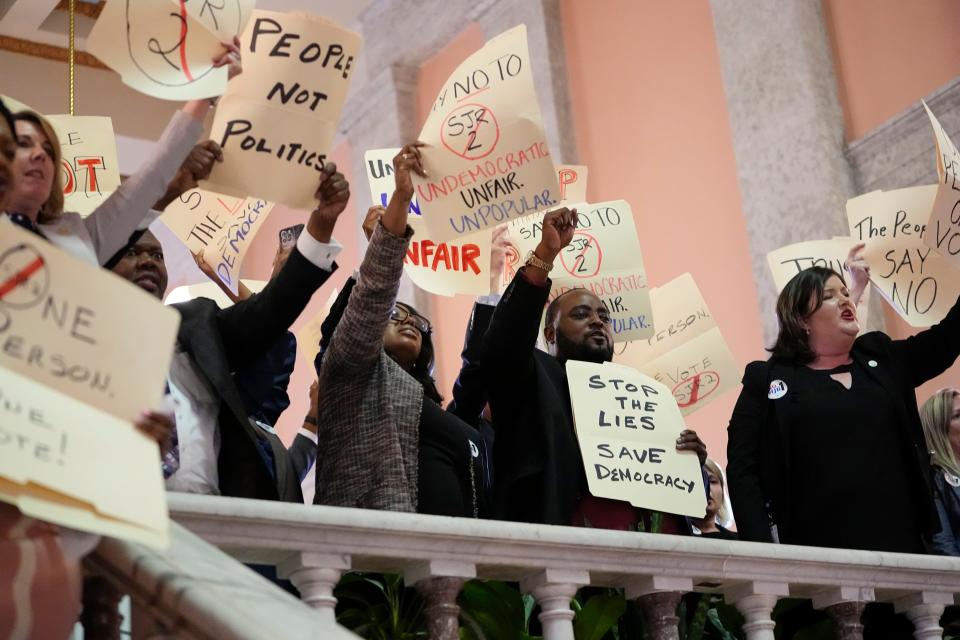 Democratic representatives chant, “One person, one vote” with protesters inside the Ohio Statehouse on Wednesday after the House voted to create an August special election for a resolution that would make it harder to change the constitution.
