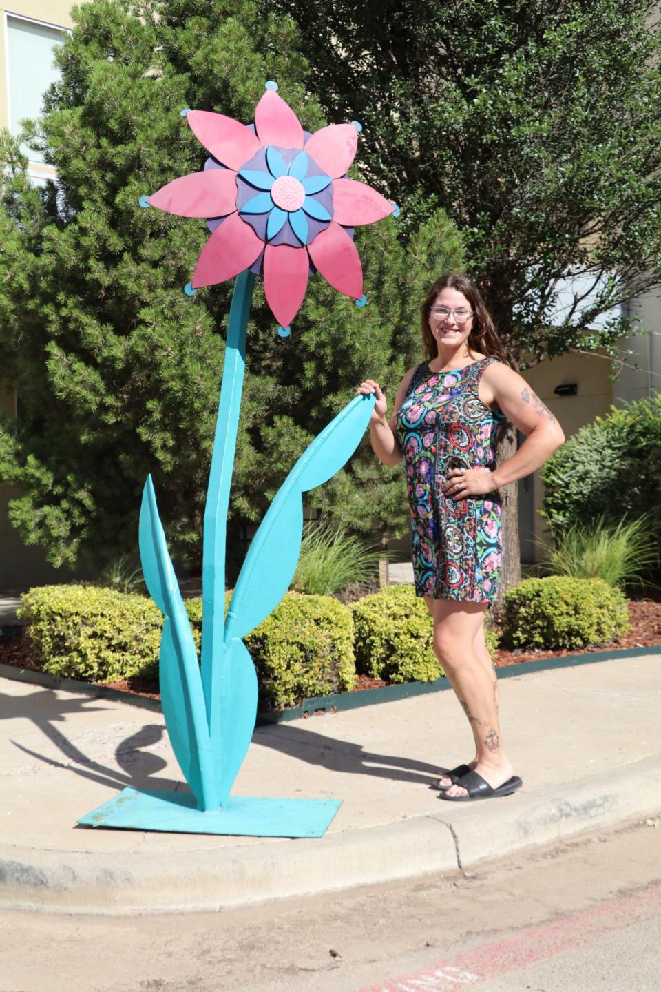 For the Lubbock Arts Festival, Glory Hartsfield has created four sculptures called “Delightful Fantasy Flowers.” Each flower measures over 13 feet tall and has bright, colorful petals and multiple heads and stems.