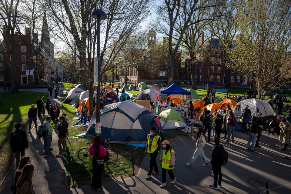 FILE - Students protesting against the war in Gaza, and passersby walking through Harvard Yard, are seen at an encampment at Harvard University in Cambridge, Mass., on Thursday, April 25, 2024. Protest camps have sprouted up over the past two weeks at dozens of campuses across the nation. Some schools have set up encampments on campuses, including Harvard University. Others like Boston College have been calm. (AP Photo/Ben Curtis, File)