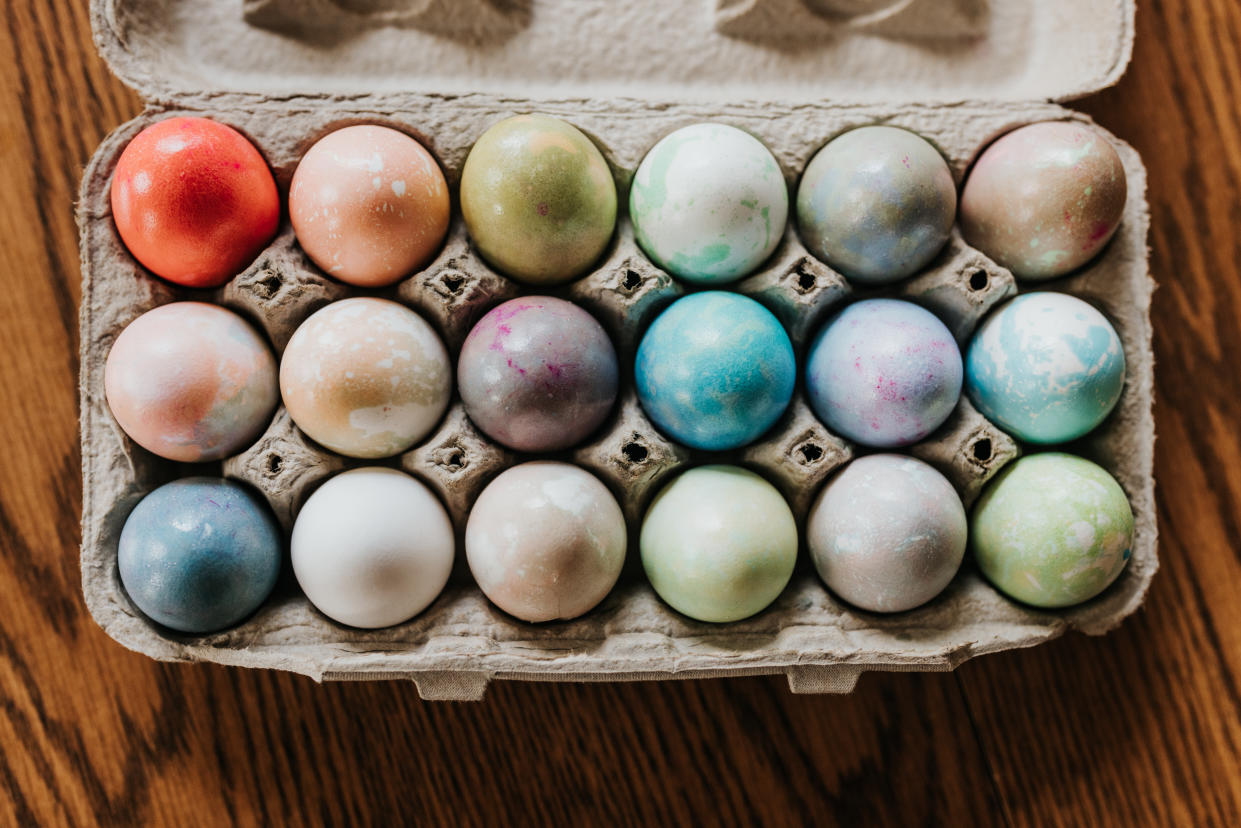 18 colorfully dyed Easter eggs in a carton.