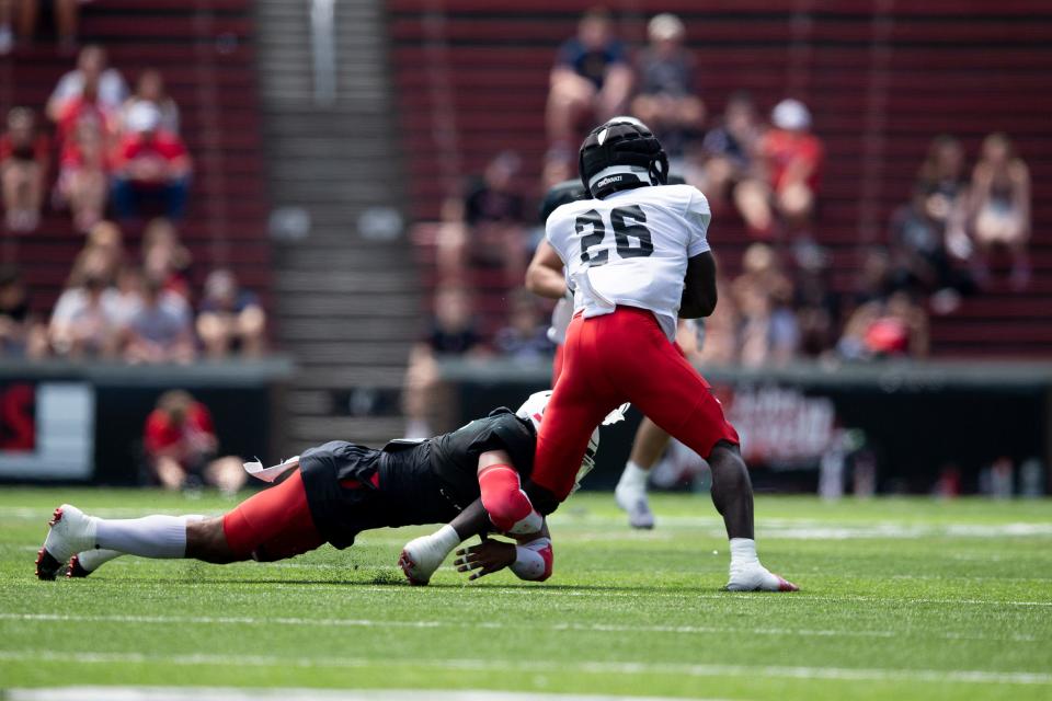 Cincinnati Bearcats defensive back Jordan Young (1) takes down Cincinnati Bearcats running back Myles Montgomery (26) during the Cincinnati Bearcats spring scrimmage at Nippert Stadium on Saturday, April 15, 2023.