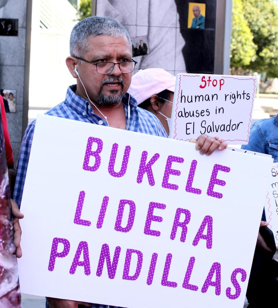 El activista salvadoreño César Fuentes sostiene un cartel en junio de 2022.