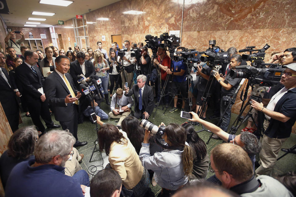 FILE - In this July 7, 2015, file photo, San Francisco Public Defender Jeff Adachi, left, talks to members of the media after Francisco Sanchez' arraignment in San Francisco. On Friday, May 24, 2019, San Francisco Police Chief William Scott apologized for raiding a freelance journalist's home and office to find out who leaked a police report into the unexpected death of the city's former public defender. Scott said the warrants didn't adequately identify Bryan Carmody as a journalist. (AP Photo/Tony Avelar, File)