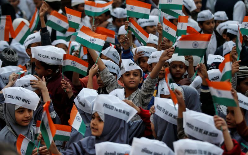 School children wearing caps with writings against a new citizenship law attend Republic Day celebrations in Ahmedabad