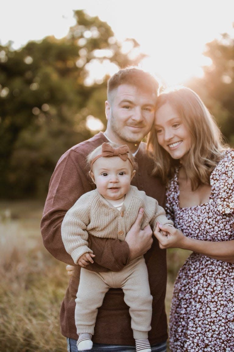 Oklahoma State wrestler Kaden Gfeller with his fiance, Cassidy Watters, and daughter Charlotte.