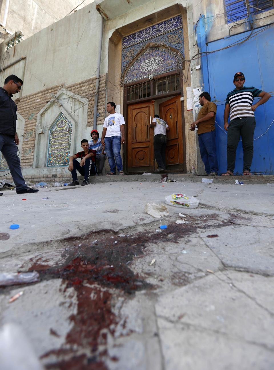 People gather at the site of a suicide bomber on a Shi'ite mosque in Baghdad May 27, 2014. (REUTERS/Thaier Al-Sudani)