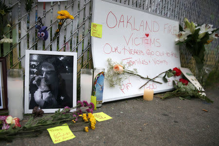 A sidewalk memorial is seen near the burned warehouse following the fatal fire in the Fruitvale district of Oakland, California, U.S. December 5, 2016. REUTERS/Lucy Nicholson