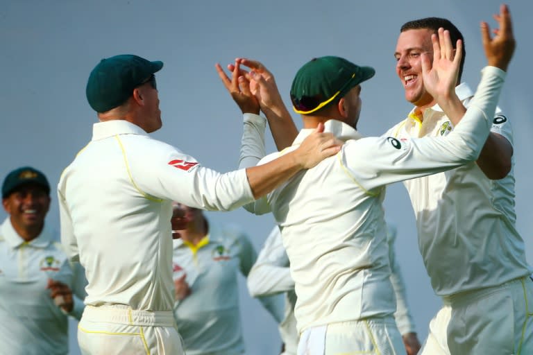 Australia's bowler Josh Hazlewood (R) celebrates with teammates David Warner and Nathan Lyon the run-out of England's batsman James Vince on the first day of their first Ashes Test, in Brisbane, on November 23, 2017