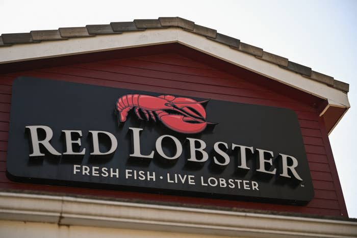 Sign above Red Lobster restaurant entrance displaying a red lobster logo and the words "Red Lobster Fresh Fish Live Lobster."