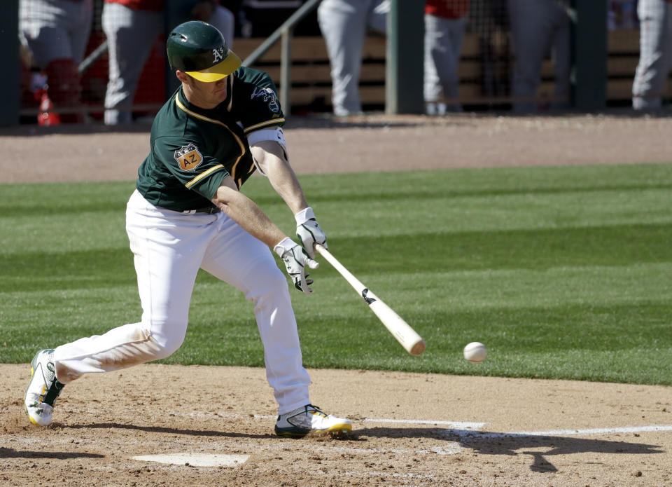 Oakland Athletics first baseman Mark Canha hits a RBI-double against the Los Angeles Angels during the third inning of a spring baseball game in Mesa, Ariz., Sunday, Feb. 26, 2017. (AP Photo/Chris Carlson)