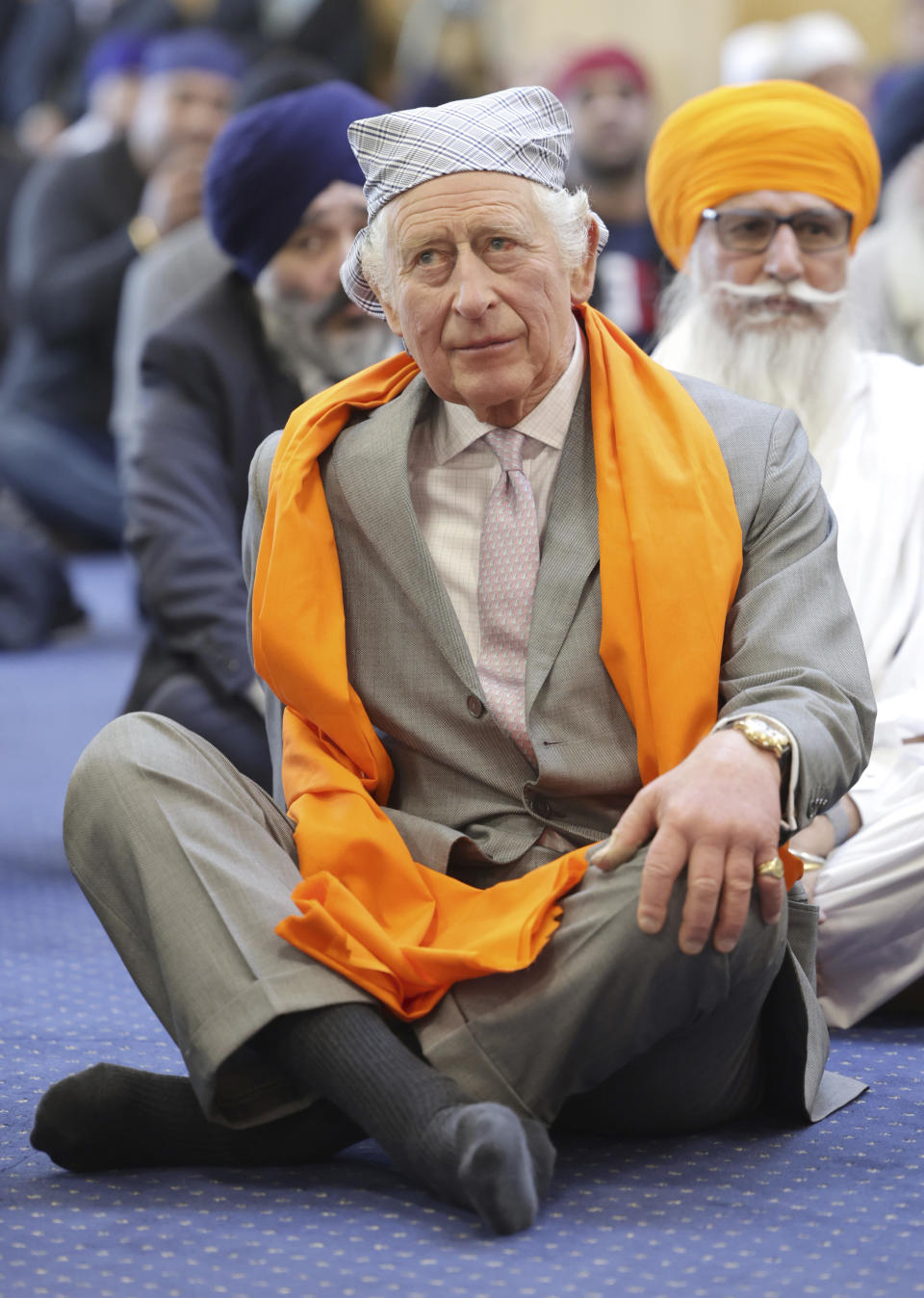 FILE - Britain's King Charles III sits on the floor in the Prayer Hall during a visit to the newly built Guru Nanak Gurdwara, in Luton, England, Tuesday, Dec. 6, 2022. (Chris Jackson/Pool Photo via AP, File)