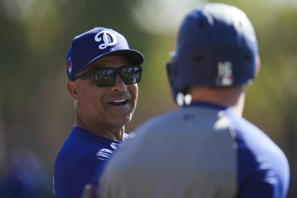 Los Angeles Dodgers manager Dave Roberts, left, talks with catcher Will Smith during spring training baseball workouts at Camelback Ranch in Phoenix, Tuesday, Feb. 13, 2024. (AP Photo/Ashley Landis)