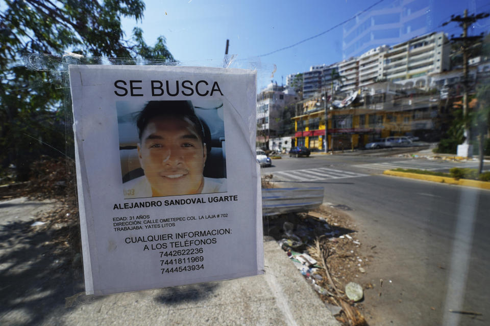 A missing persons sign hangs on a window at a bus stop in Acapulco, Mexico, Sunday, Nov. 12, 2023. It was 12:20 a.m. on Oct. 25. when Hurricane Otis made landfall in this Pacific port city as a Category 5 hurricane, leaving 48 dead, mostly by drowning, and 31 missing, according to official figures. Sailors, fishermen and relatives of crew members believe that there may be more missing because sailors often go to take care of their yachts when a storm approaches. (AP Photo/Marco Ugarte)