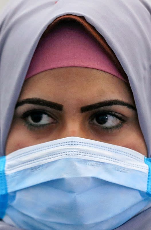 A woman wearing a protective face mask works in a factory that produces sterilised surgical equipment and medical clothings in Egypt