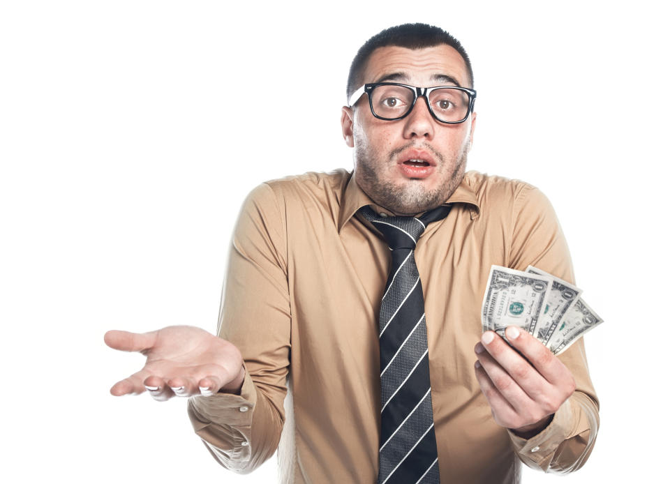 Man in collared shirt and tie, holding money and shrugging