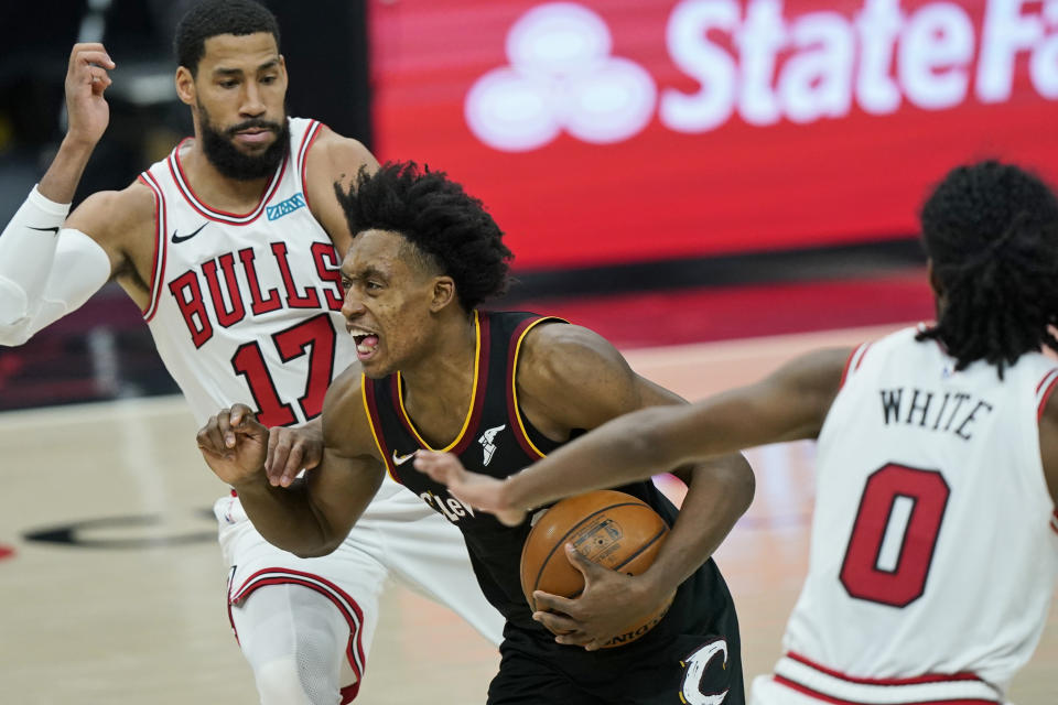 Cleveland Cavaliers' Collin Sexton, center, drives between Chicago Bulls' Garrett Temple, left, and Coby White during the second half of an NBA basketball game Wednesday, April 21, 2021, in Cleveland. (AP Photo/Tony Dejak)