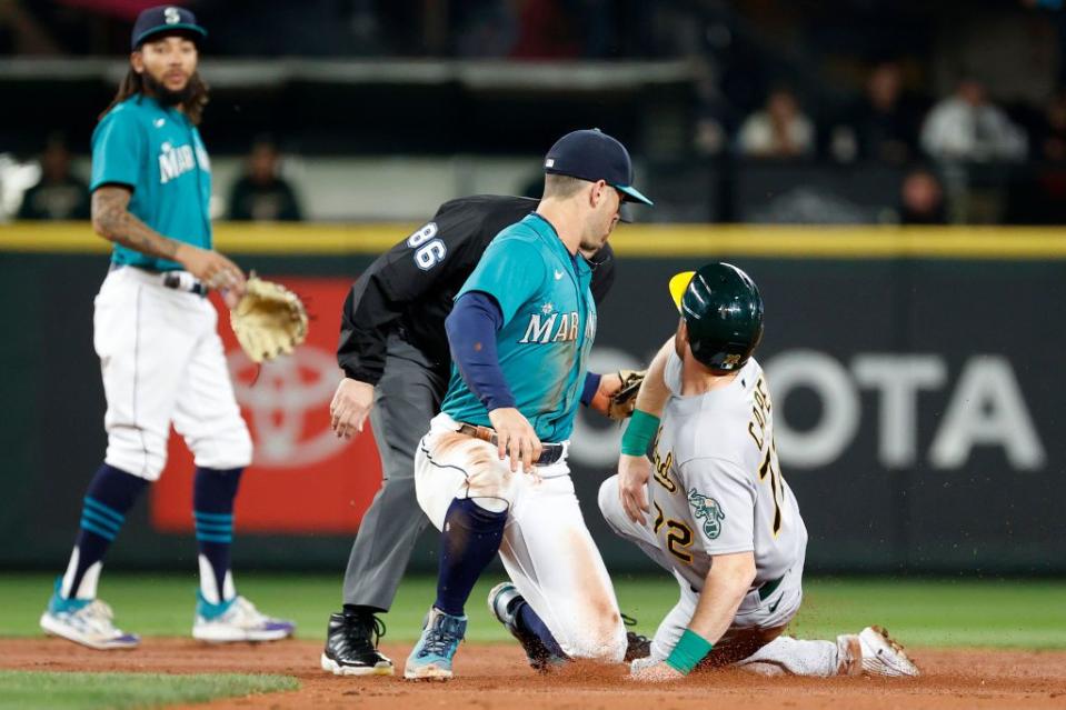 SEATTLE, WASHINGTON - SEPTEMBER 30: Dylan Moore #25 of the Seattle Mariners tags out Conner Capel #72 of the Oakland Athletics during the second inning  at T-Mobile Park on September 30, 2022 in Seattle, Washington. (Photo by Steph Chambers/Getty Images)