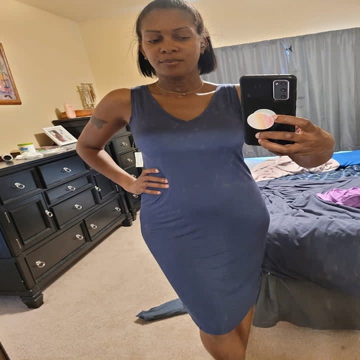 reviewer in V-neck blue dress