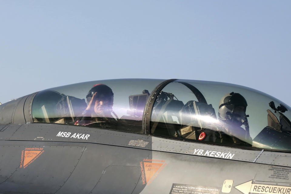 Turkey's Defense Minister Hulusi Akar, left, salutes from inside an F-16 jet fighter at a military air base in western city of Eskisehir, Turkey, Wednesday, Sep. 2, 2020, before a training flight over Turkish Monument in Gallipoli peninsula. Akar said Thursday that Washington's lifting the arms embargo against Greek Cypriot-administered Cyprus will lead to a deadlock. "If you lift the embargo and try to disrupt the balance in this way, this will bring conflict, not peace," he said.(Turkish Defense Ministry via AP, Pool)