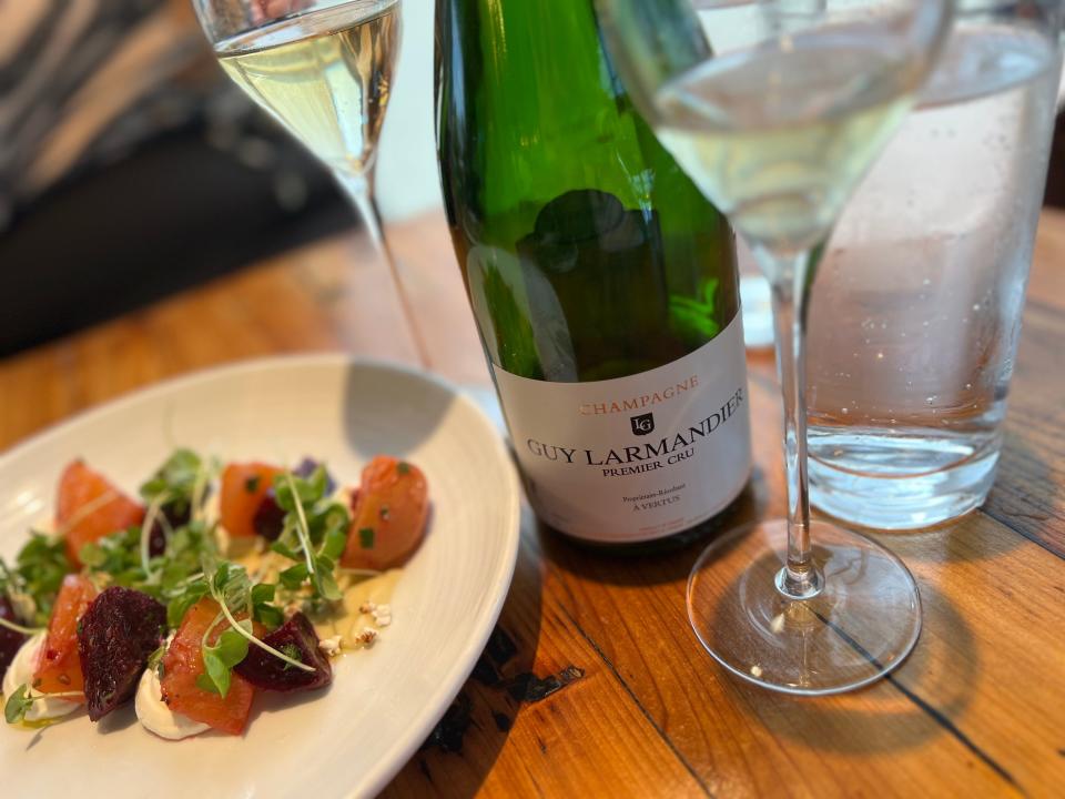 plate of food, bottle of wine, and wine glasses on a table at a restaurant in disney springs