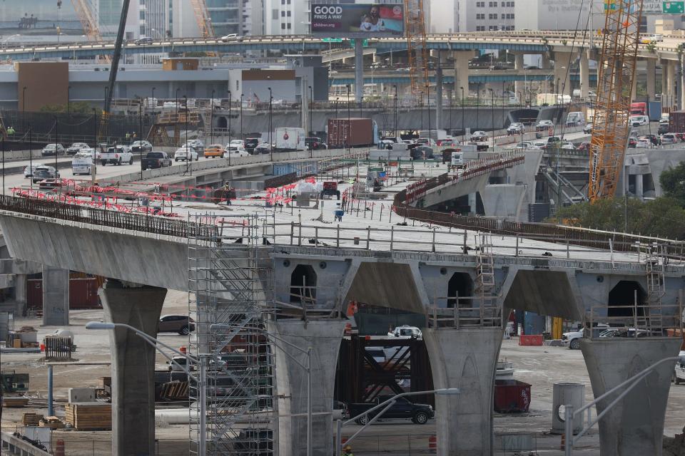 MIAMI, FLORIDA - MARCH 17: Construction workers build the “Signature Bridge,” replacing and improving a busy highway intersection at I-95 and I-395 on March 17, 2021 in Miami, Florida. The Florida Department of Transportation is building the project in partnership with the Miami-Dade Expressway.