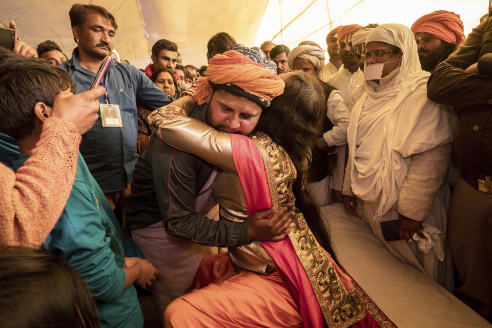 In this Jan. 14, 2019, photo, a Hindu devotee embraces Laxmi Narayan Tripathi, transgender activist and leader of "Kinnar Akhara" monastic order, during the Kumbh Mela festival in Prayagraj, India. Tripathi, who is also a Bollywood reality TV star and former Asia Pacific representative to the UN, is trying to break into the male-dominated world of Hinduism’s high priests gathered this month in the north Indian city of Prayagraj on the Ganges river for the weeks-long Kumbh Mela festival, where tens of millions of Hindus travel every three years to take a holy dip. Unlike other akharas, which are only open to Hindu men, Kinnar, founded in 2015, is open to all genders and religions. (AP Photo/Bernat Armangue)